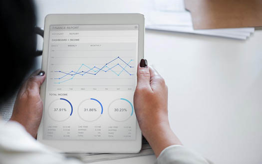 Woman holding a tablet displaying financial data