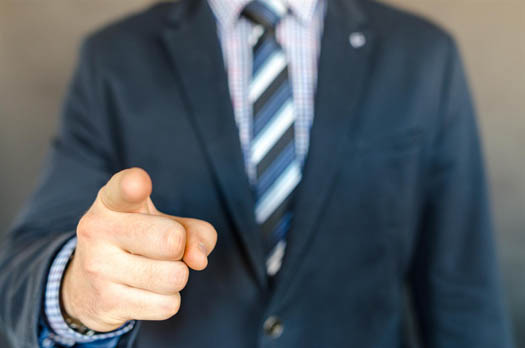 A business man pointing at the camera