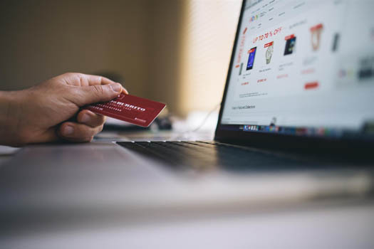 Man using a credit card to pay online bills to slim down a budget