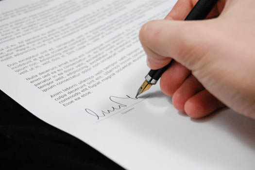Man signing nonprofit insurance document to minimize risk