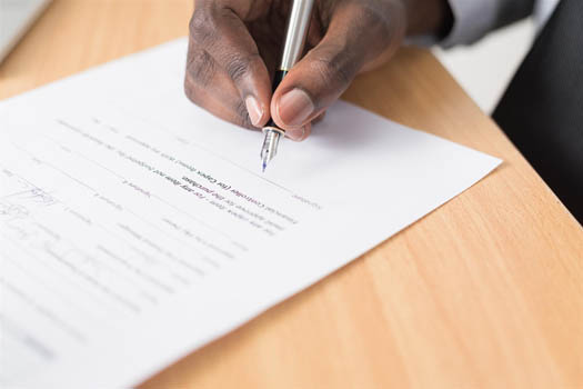 Man holding a pen signing a letter of intent