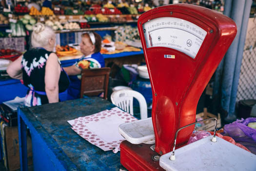 A scale on a table in a open air farmers market