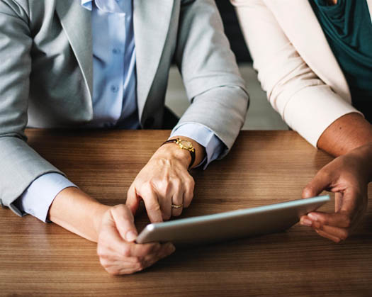 Man & woman holding a tablet and looking at company data