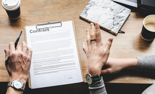 Employees discussing the build vs buy equation with a clipboard on a table with coffee