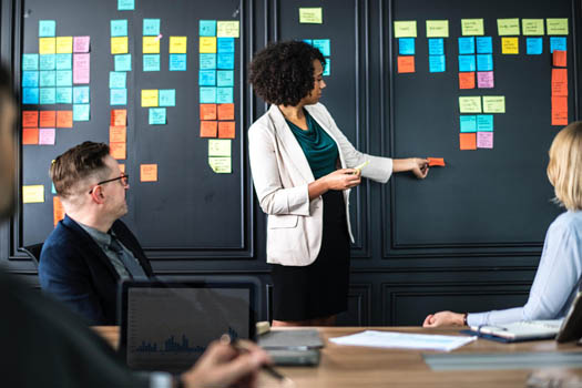Woman explaining leverage vs. delegation to colleages